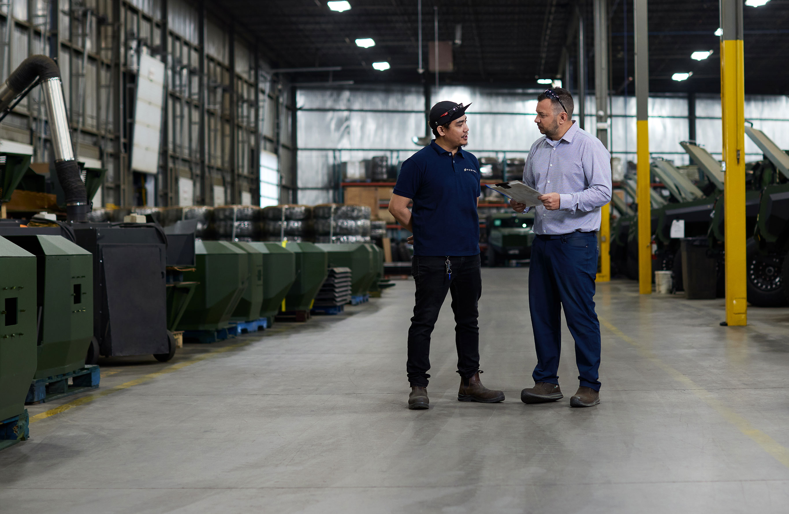 Header Image. Factory floor with two male workers talking